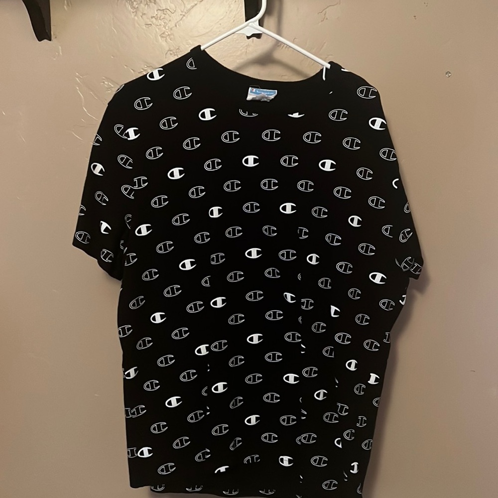 ITS A CHAMPION T SHIRT ITS IN LARGE, BLACK AND WHITE WITH WHITE CHAMPION LOGOS